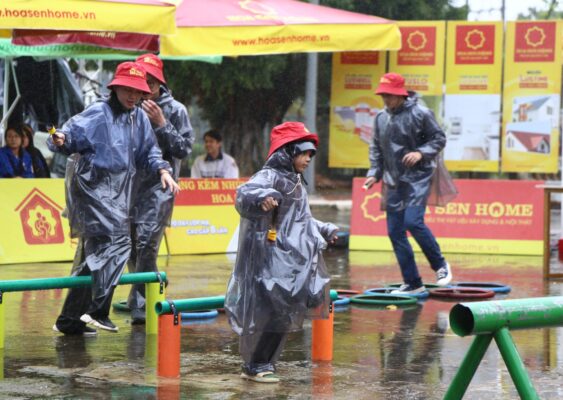 MC Anh Quân, diễn viên Băng Di và diễn viên Samuel An bất chấp mưa gió để thực hiện thử thách. 